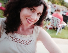 A woman with dark hair smiles at the camera. 